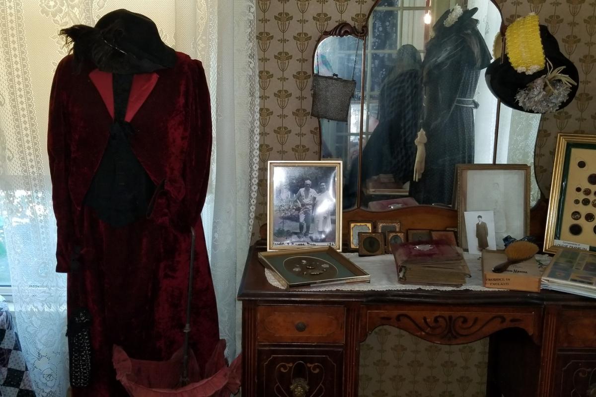 Dress on display next to antique dresser